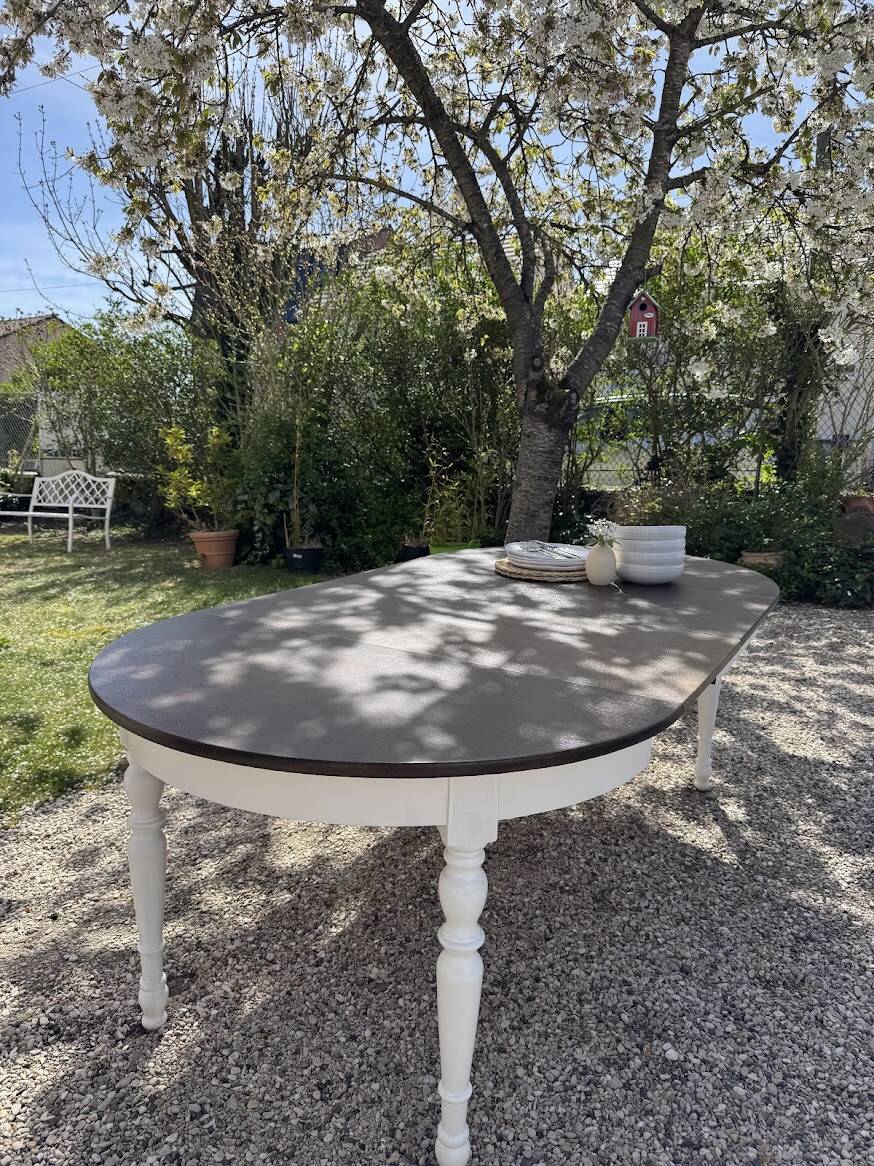 Restored solid wood round table with integrated extensions.