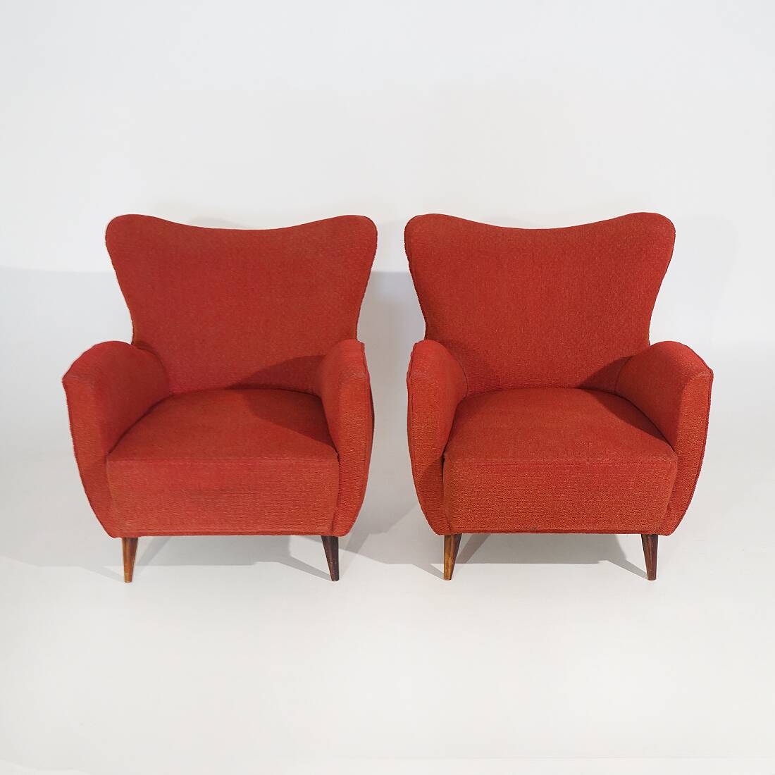 Pair of red armchairs with cone-shaped feet, 1950s