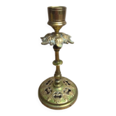 Antique brass candlestick with patina, openwork vintage foliage decoration.