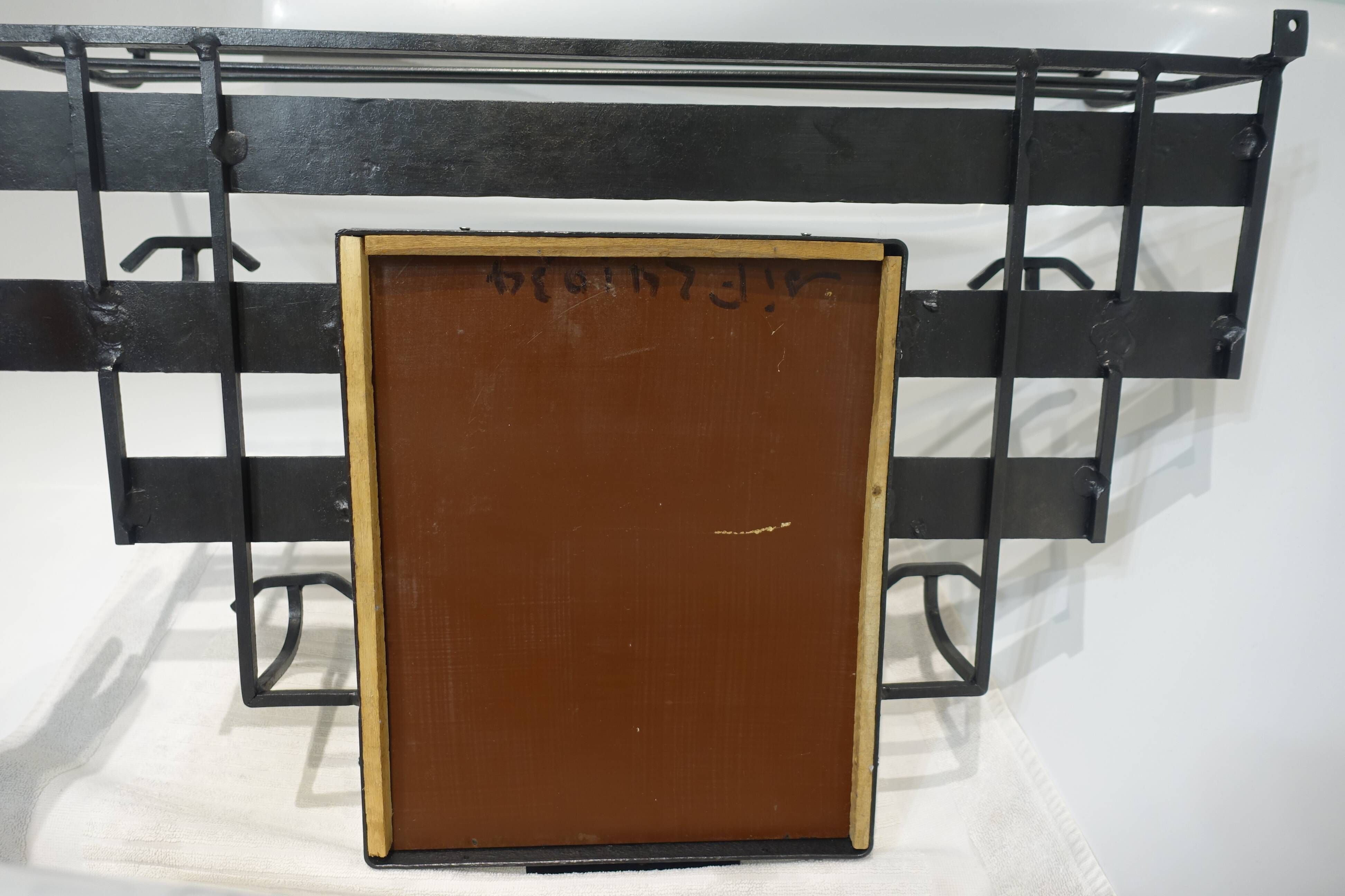 Art Deco wrought iron coat rack with bevelled mirror.