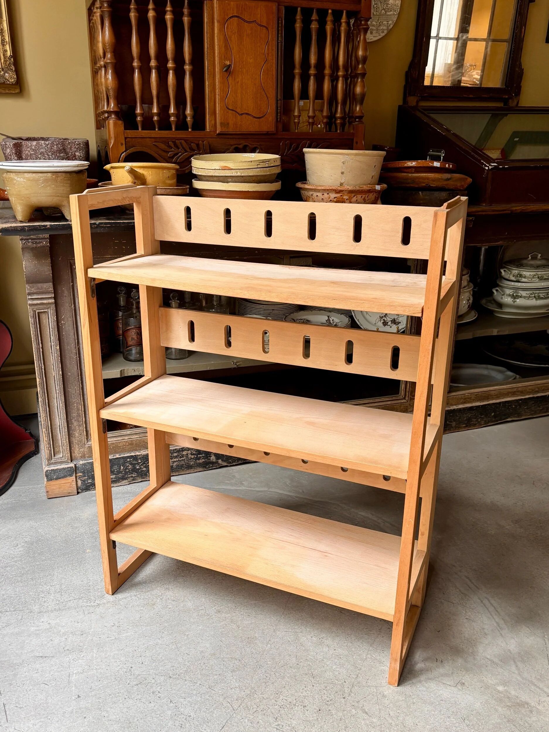 Folding bookshelf in light wood.