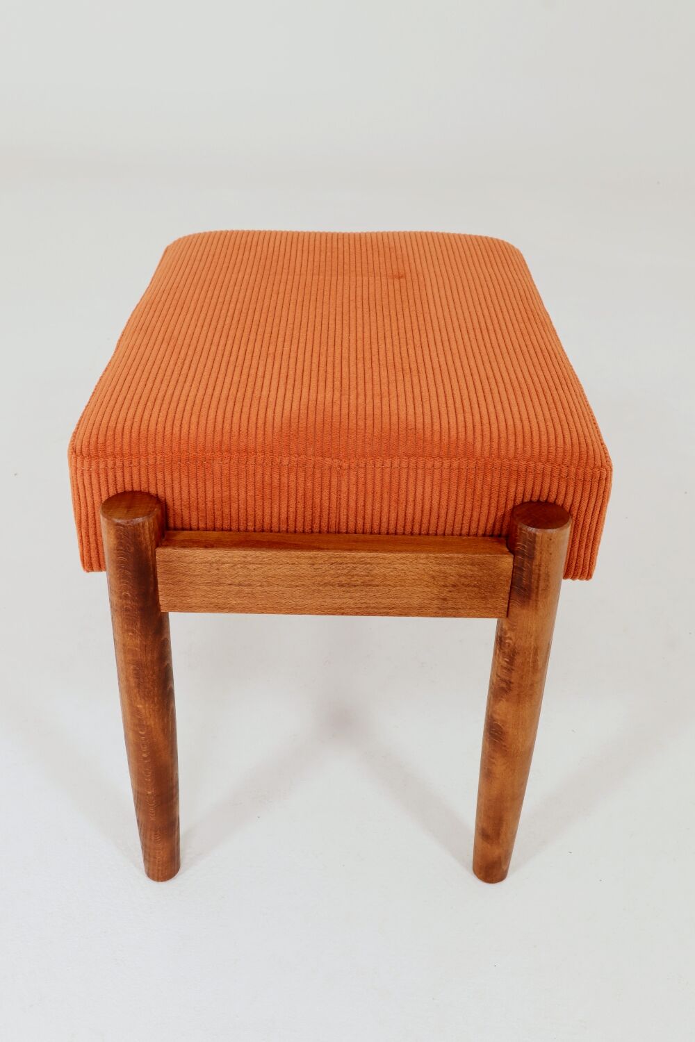 Vintage armchair and footrest in orange corduroy.