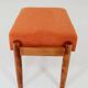Vintage armchair and footrest in orange corduroy.
