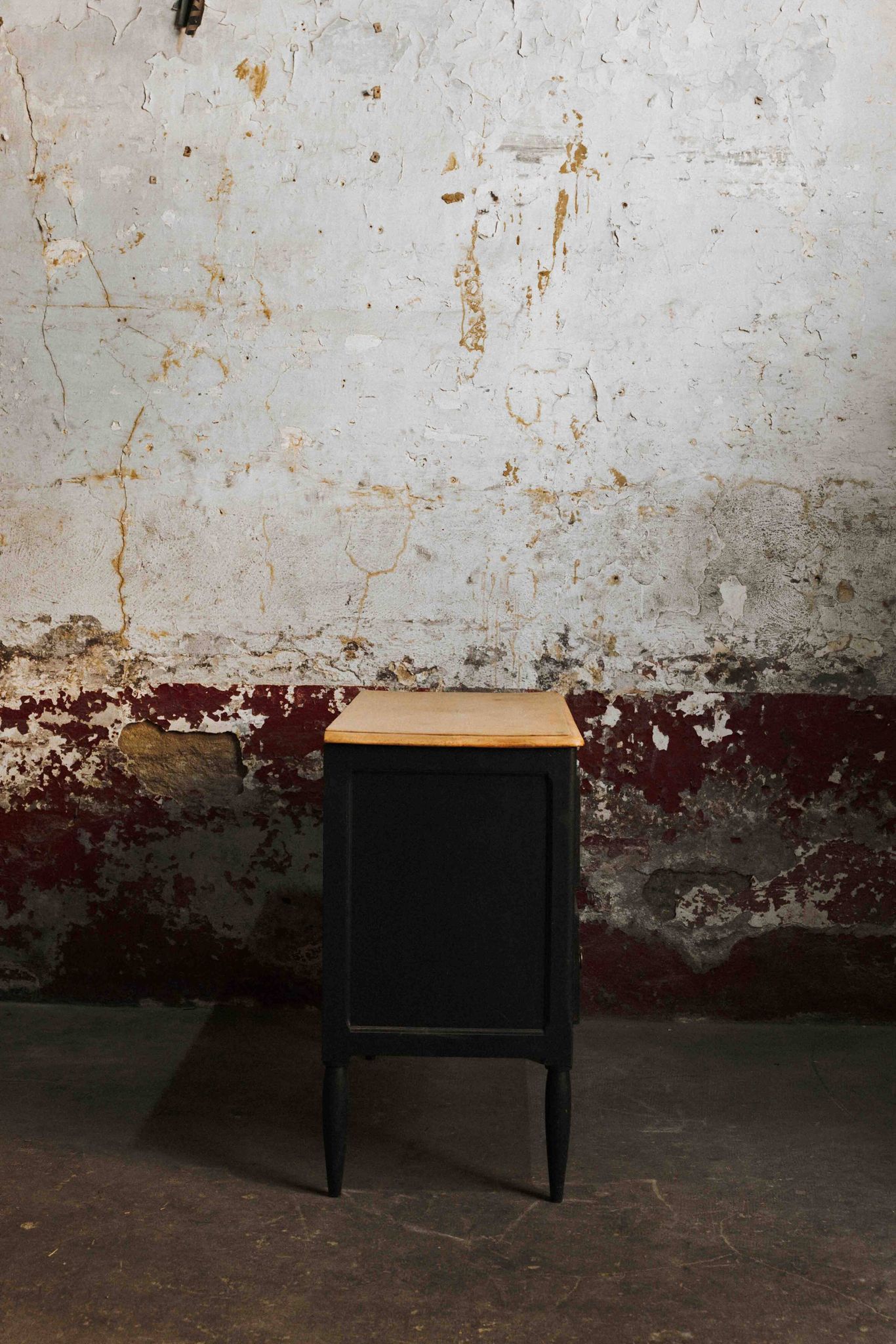 Commode noire à 2 tiroirs, plateau en bois brut et pied fuselés