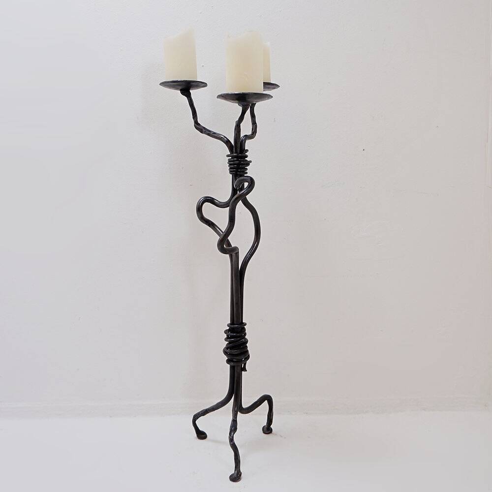 Large wrought iron candelabrum with an abstract design and three candle holders.