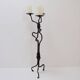 Large wrought iron candelabrum with an abstract design and three candle holders.