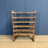 Old wooden workshop shelf with cast iron wheels.