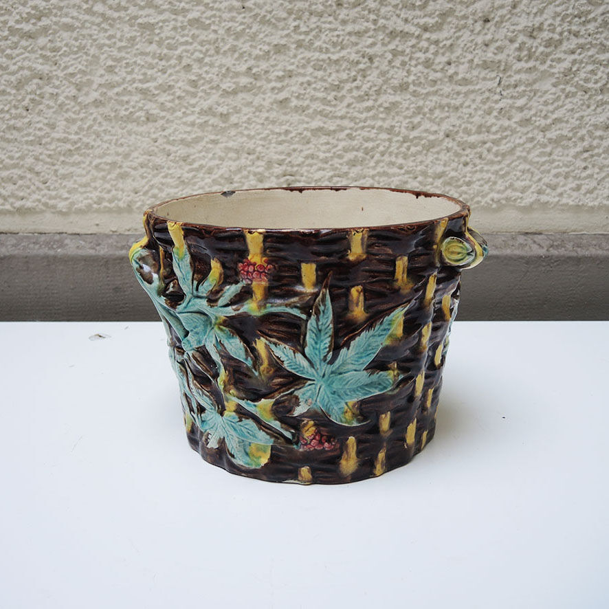 Old earthenware pot with ivy decoration.