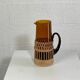 Vintage service for orangeade in amber glass and wicker.