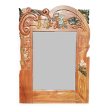 Pretty beveled mirror with wooden frame and floral decoration.