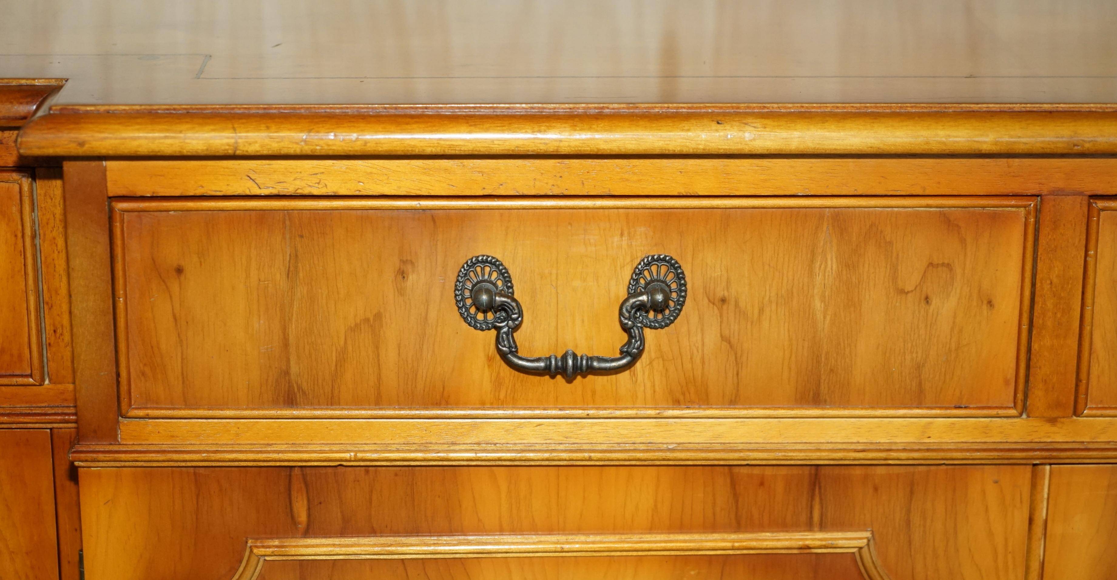 Vintage buffet made of mottled yew wood with three doors and four drawers.