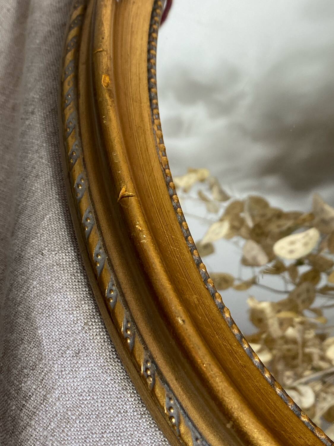 Oval-shaped gilded wooden mirror
