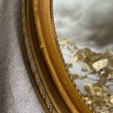 Oval-shaped gilded wooden mirror