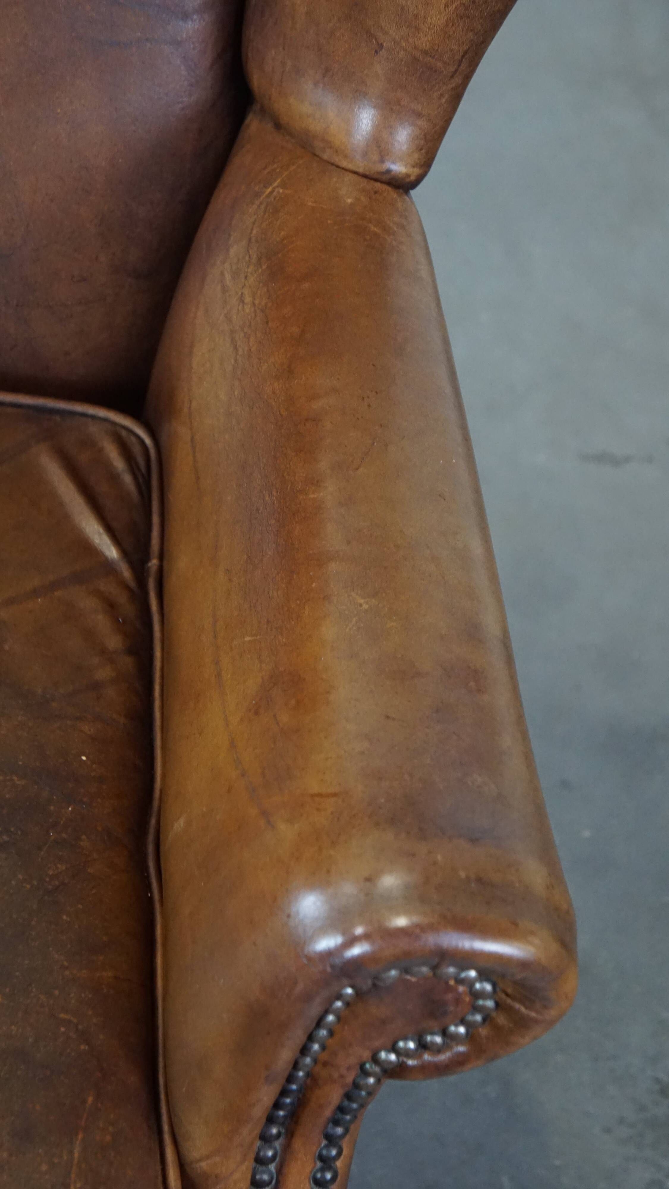 Charming sheep leather wingback armchair with a beautiful patina and excellent seating comfort