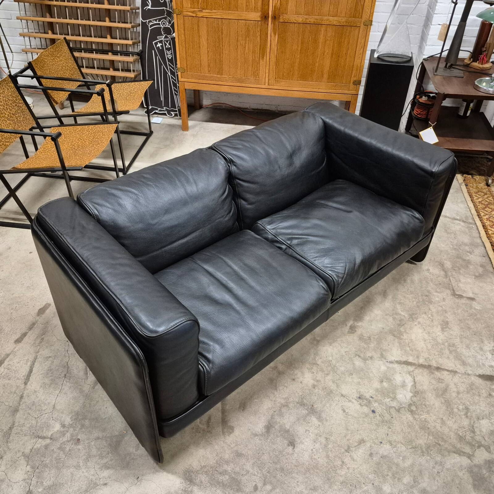 Two-seater sofa in black leather, designed by Tito Agnoli for Poltrona Frau, Italy, 1980s