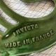 Enamelled cast iron trivet with sign decoration.