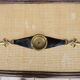 Old armrest ashtray with fleur-de-lis design in leather and brass.