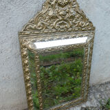 Miroir ancien à pare-closes en laiton repoussé doré 72 x 42 cm