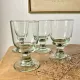 4 stemmed glasses made of handcrafted blown glass in green hue.