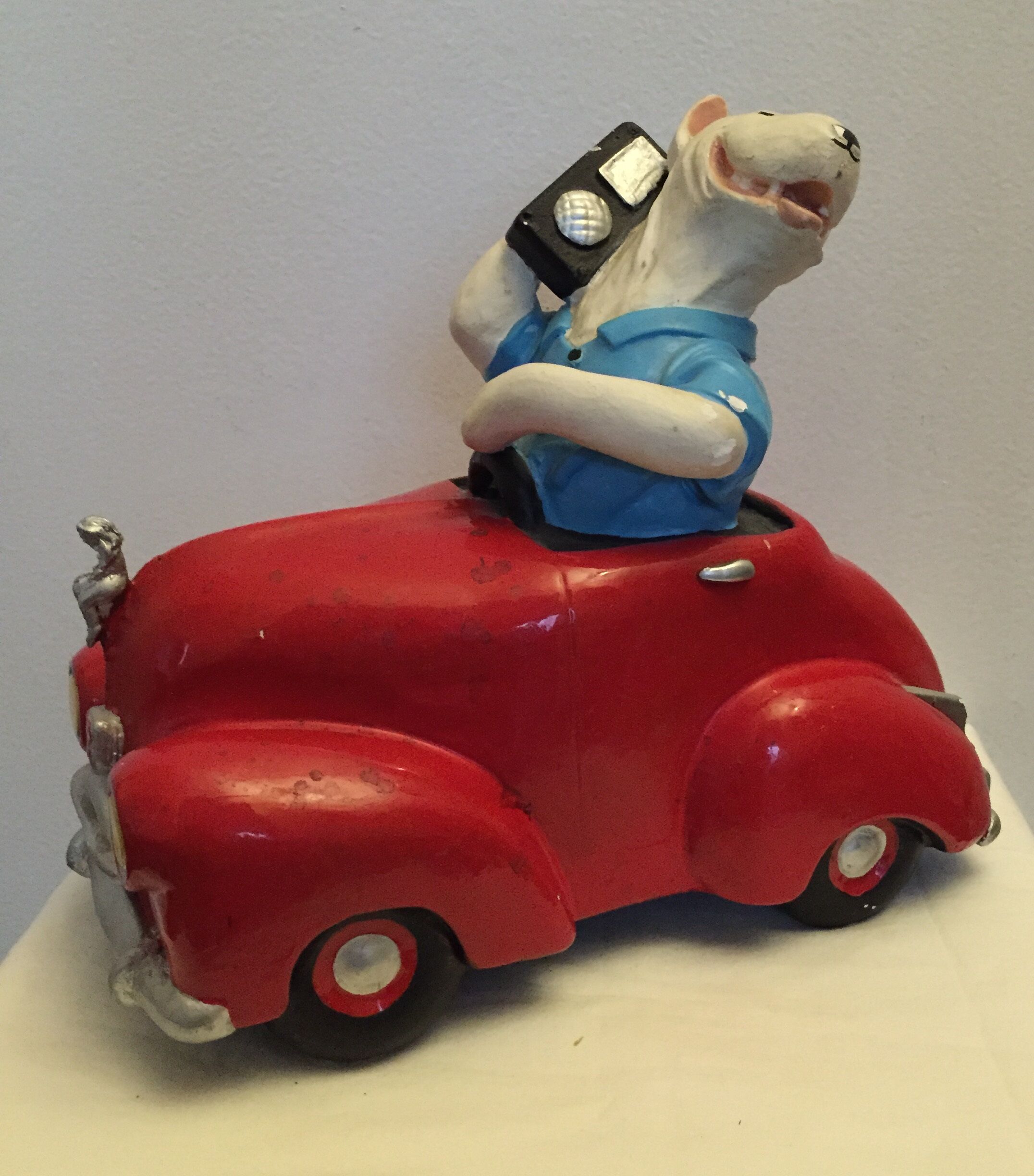 Dog toy driving his red car