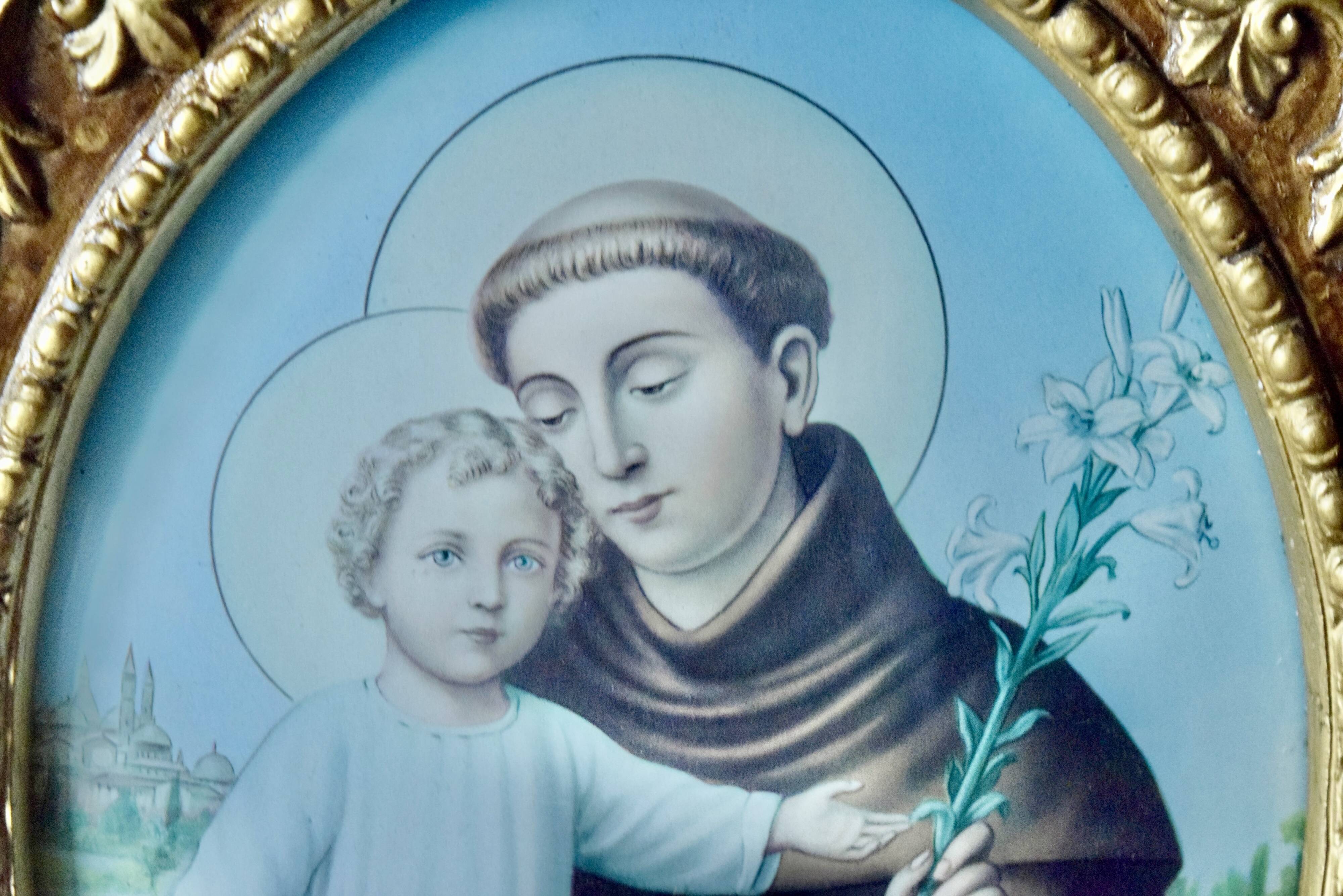 Old religious light frame in gilded stucco and curved glass