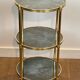 Round bronze side table with triple shelves of églomisé mirrors from Maison Baguès