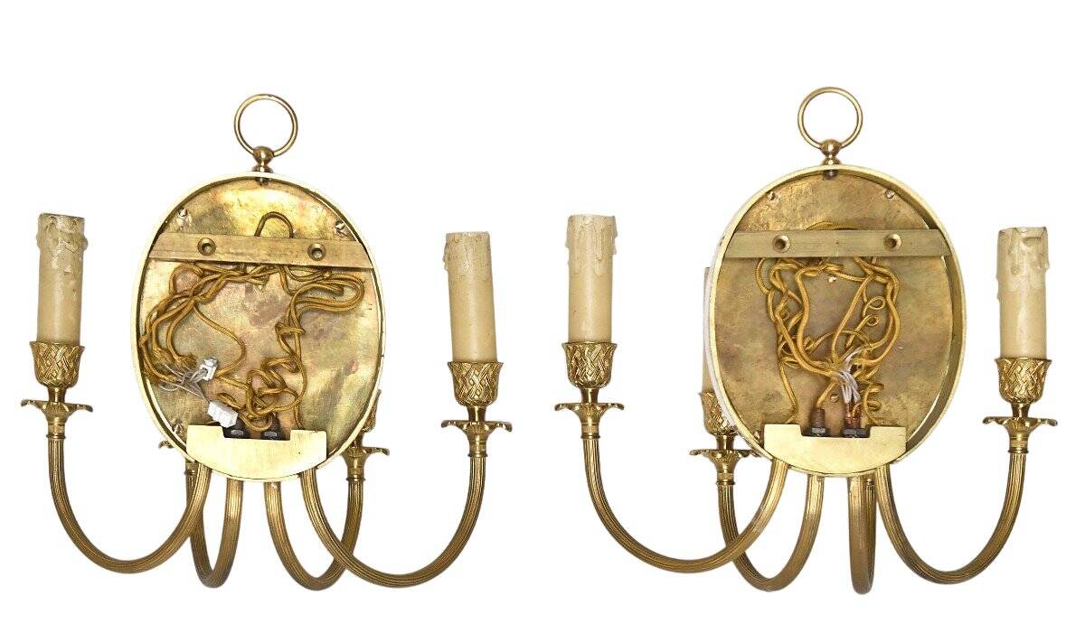 Pair of wall sconces with a relief decoration of a Bacchus mask.