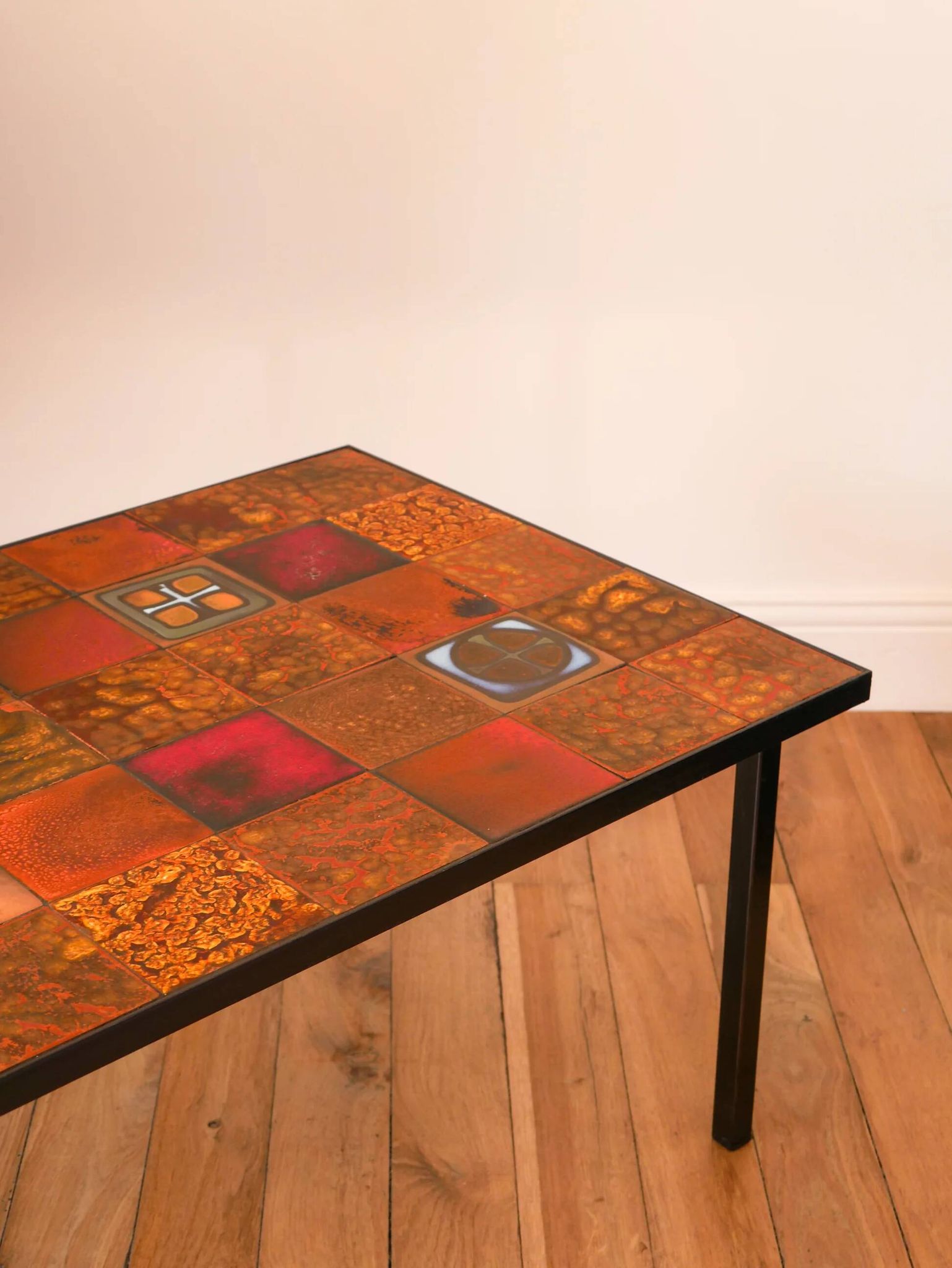 Ceramic and black iron coffee table, attributed to the Roche-Bobois brand, with a black metal base and structure, rectangular ceramic top from Vallauris with colourful patterns in ochre and orange, design from the 1970s.