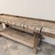 Antique wooden workbench with a vice and drawer.