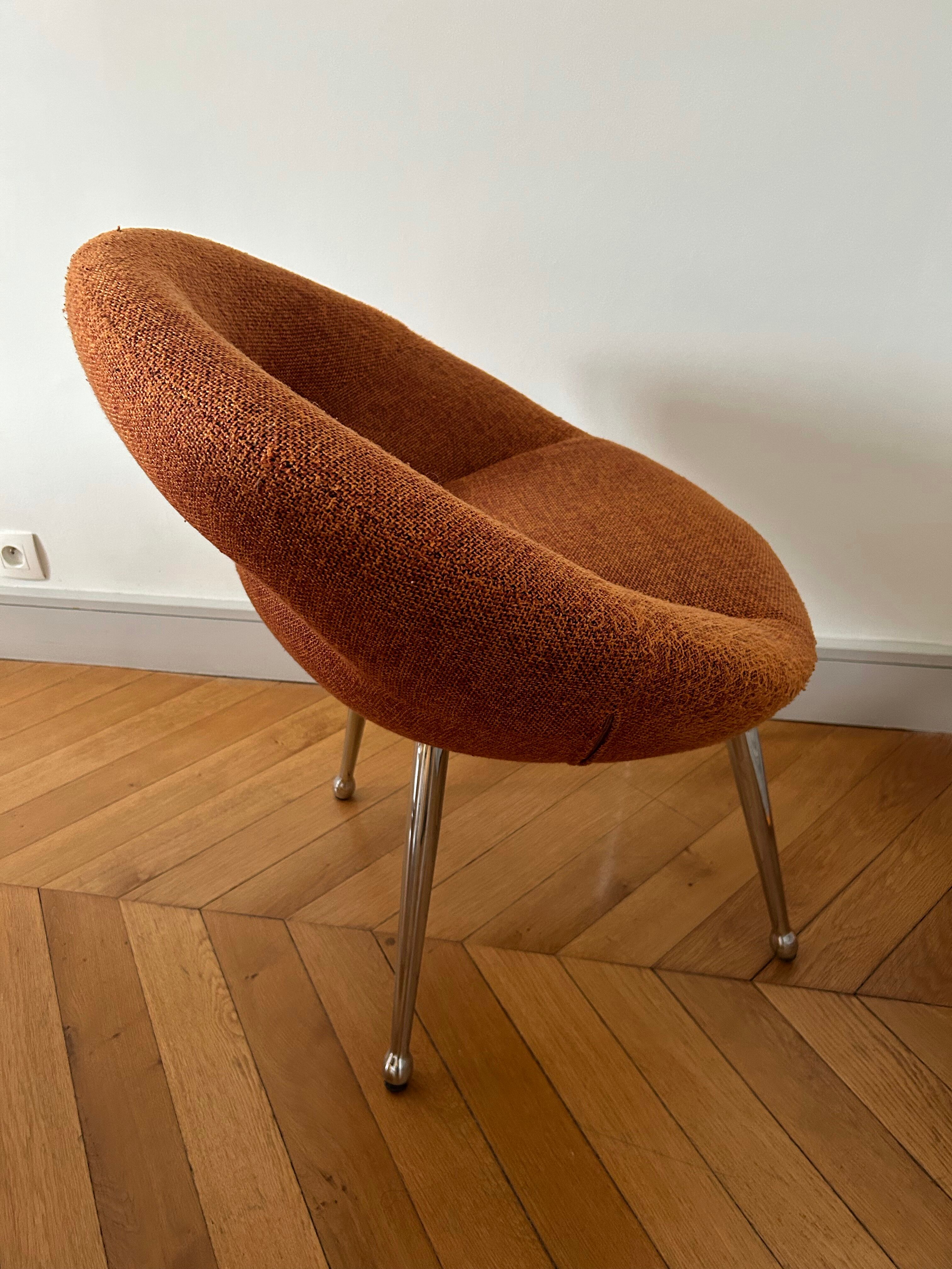 Circular armchair trimmed with orange fabric