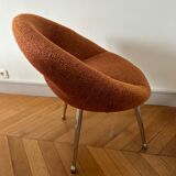 Circular armchair trimmed with orange fabric