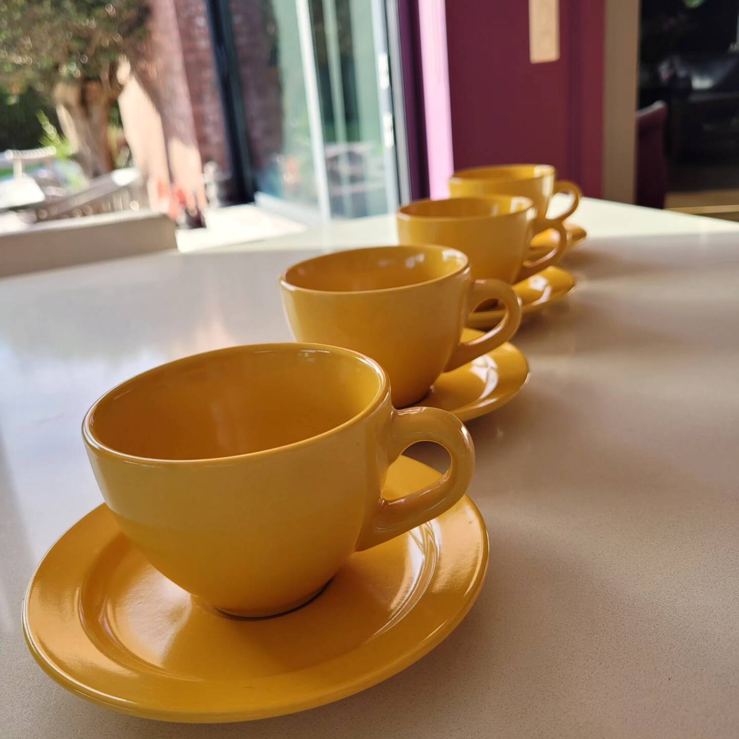 4 yellow cups and saucers