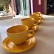 4 yellow cups and saucers