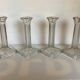 Four old square glass moulded candlesticks.