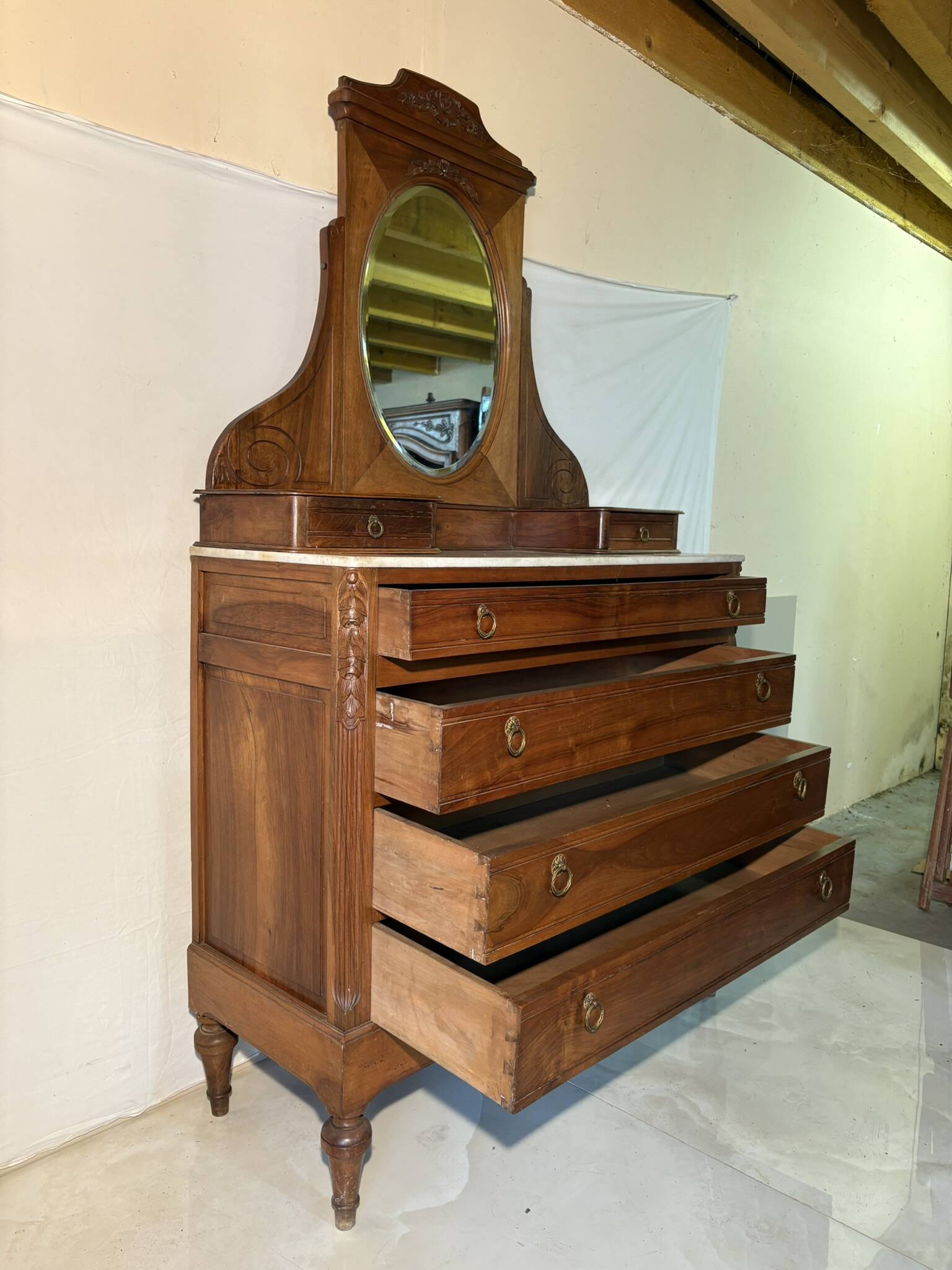 Antique carved wooden dressing table with marble and tilting oval mirror.