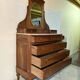 Antique carved wooden dressing table with marble and tilting oval mirror.