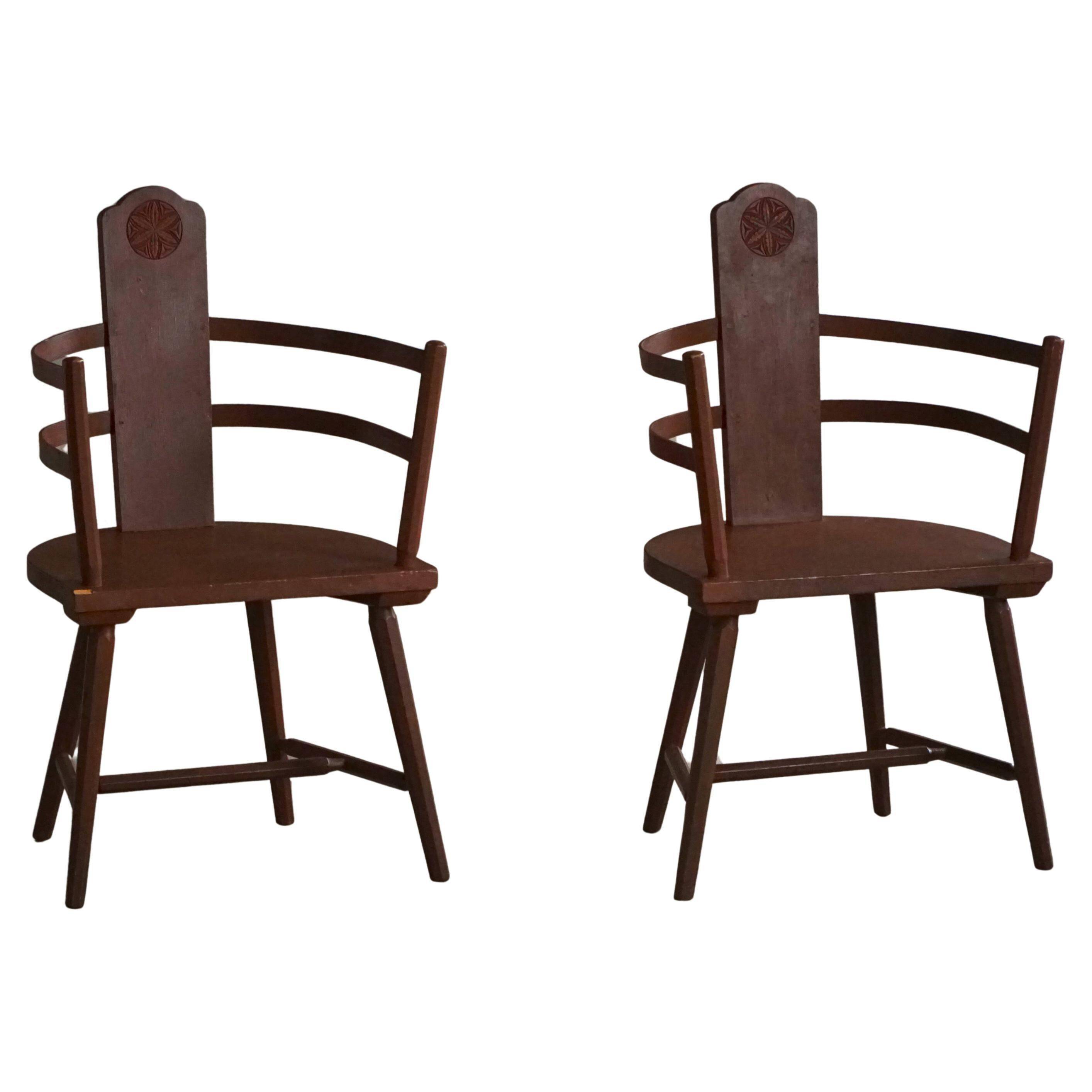 Pair of Scandinavian wooden armchairs with hand-carved folk motifs, 1920s.