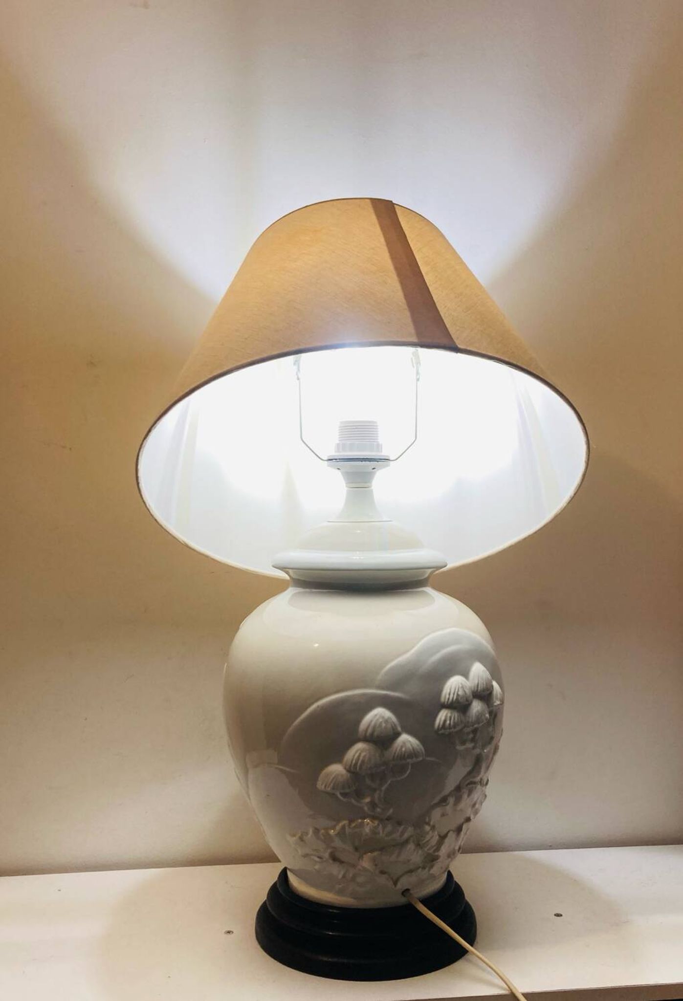 1980s ceramic table lamp with a wooden base and adjustable shade.
