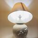 1980s ceramic table lamp with a wooden base and adjustable shade.