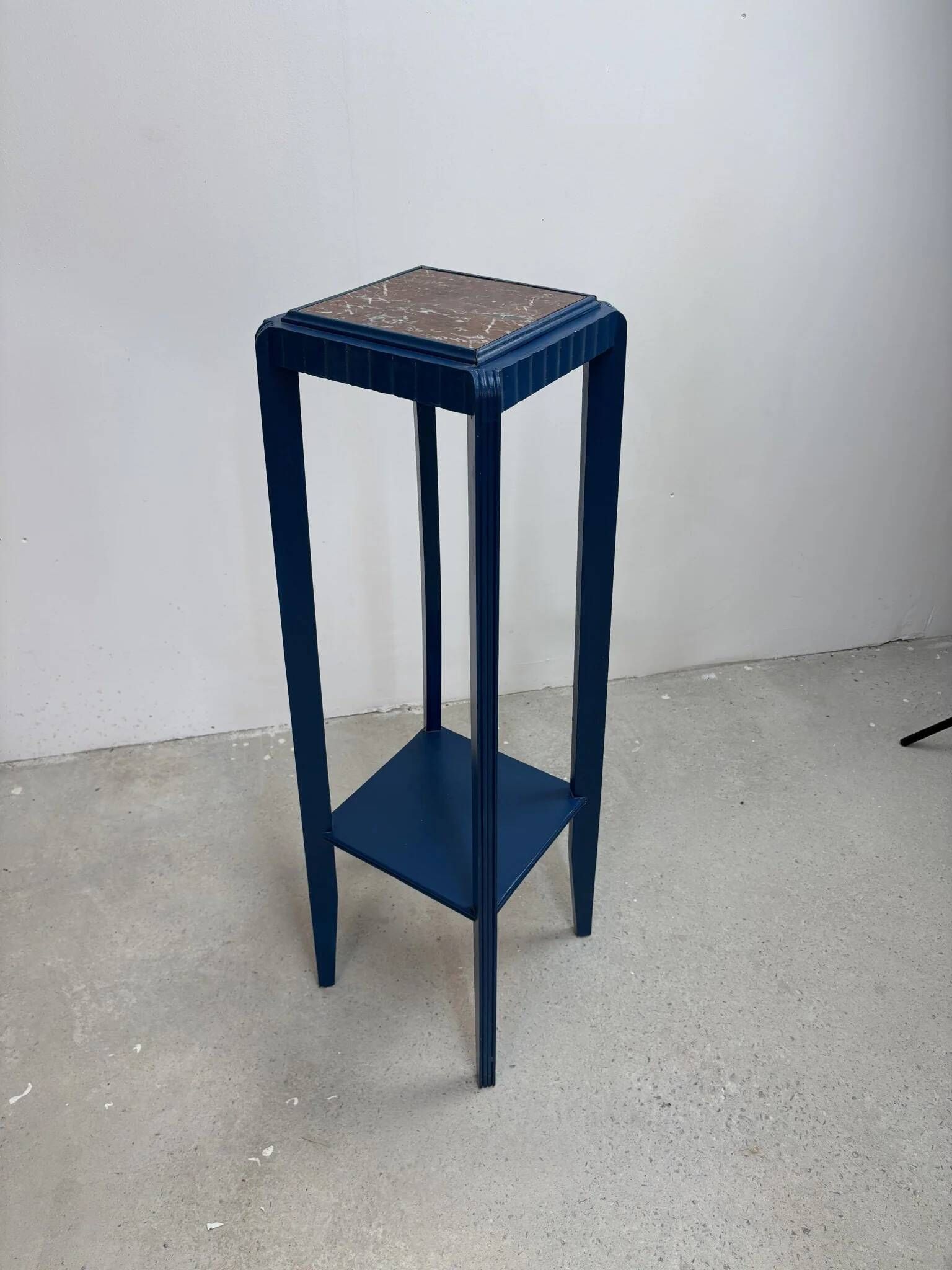 Blue side table with a veined stone top and a low shelf in the Art Deco style.