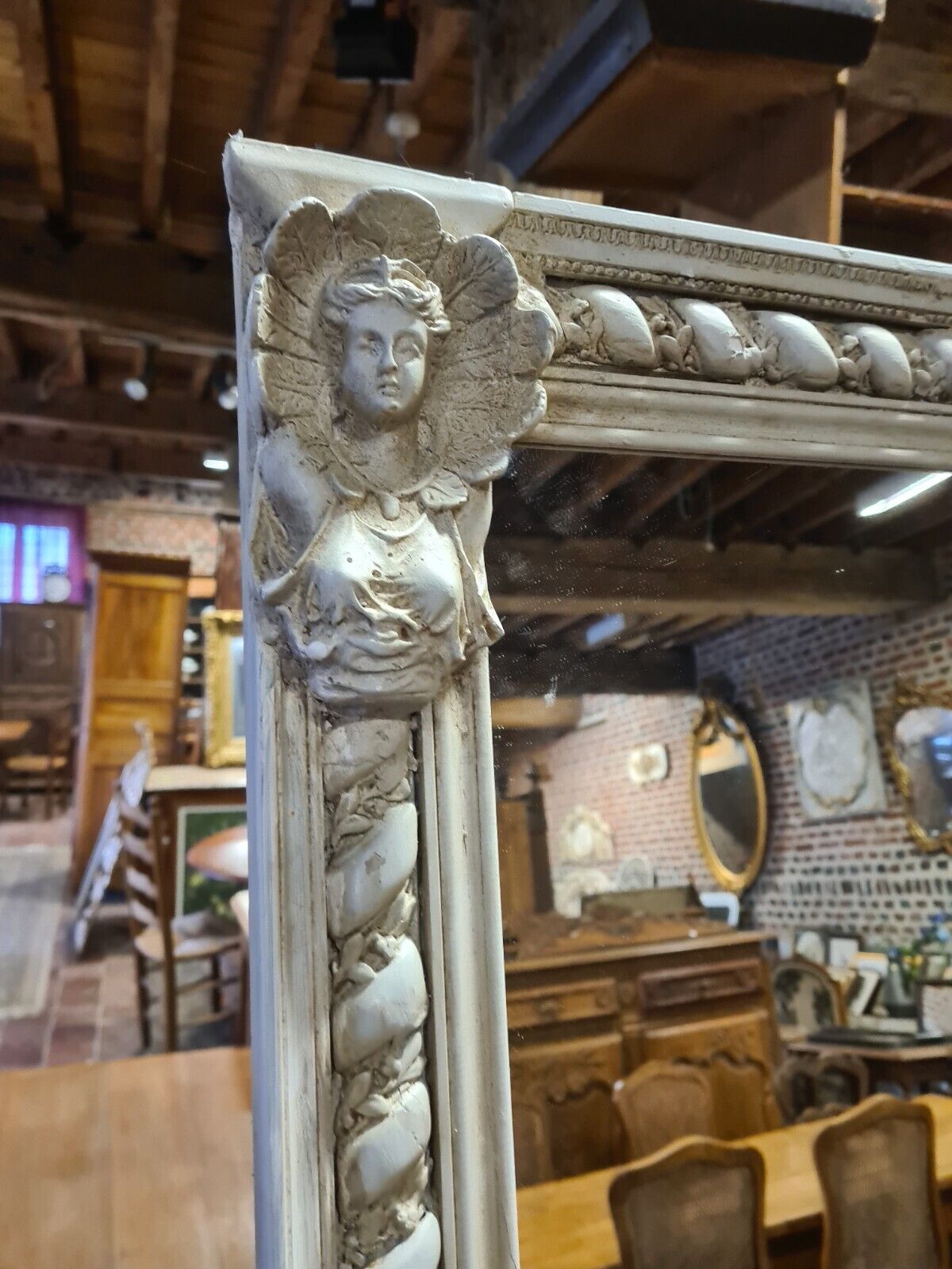 Beige patinated mirror with women's heads