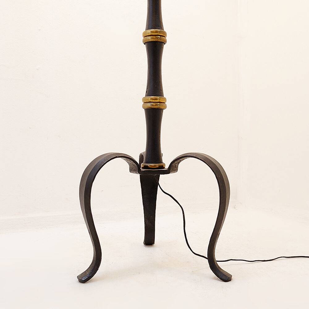 Tripod floor lamp in wrought iron and brass with bamboo-style base.