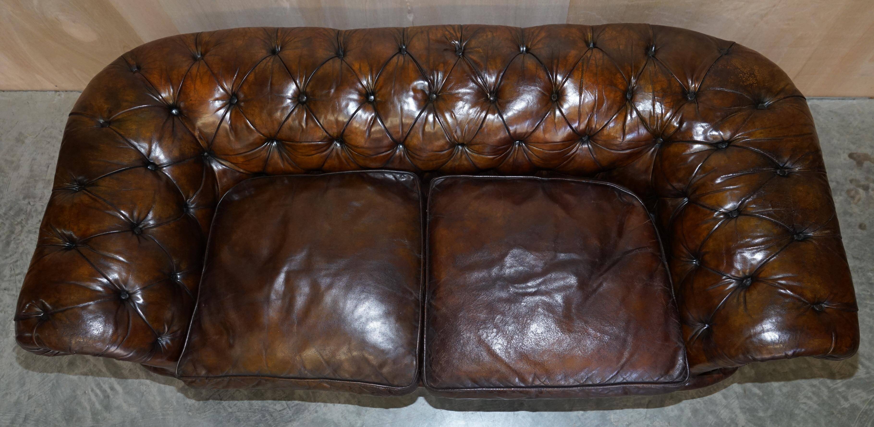 Victorian Chesterfield leather upholstered canapé with feather cushions.