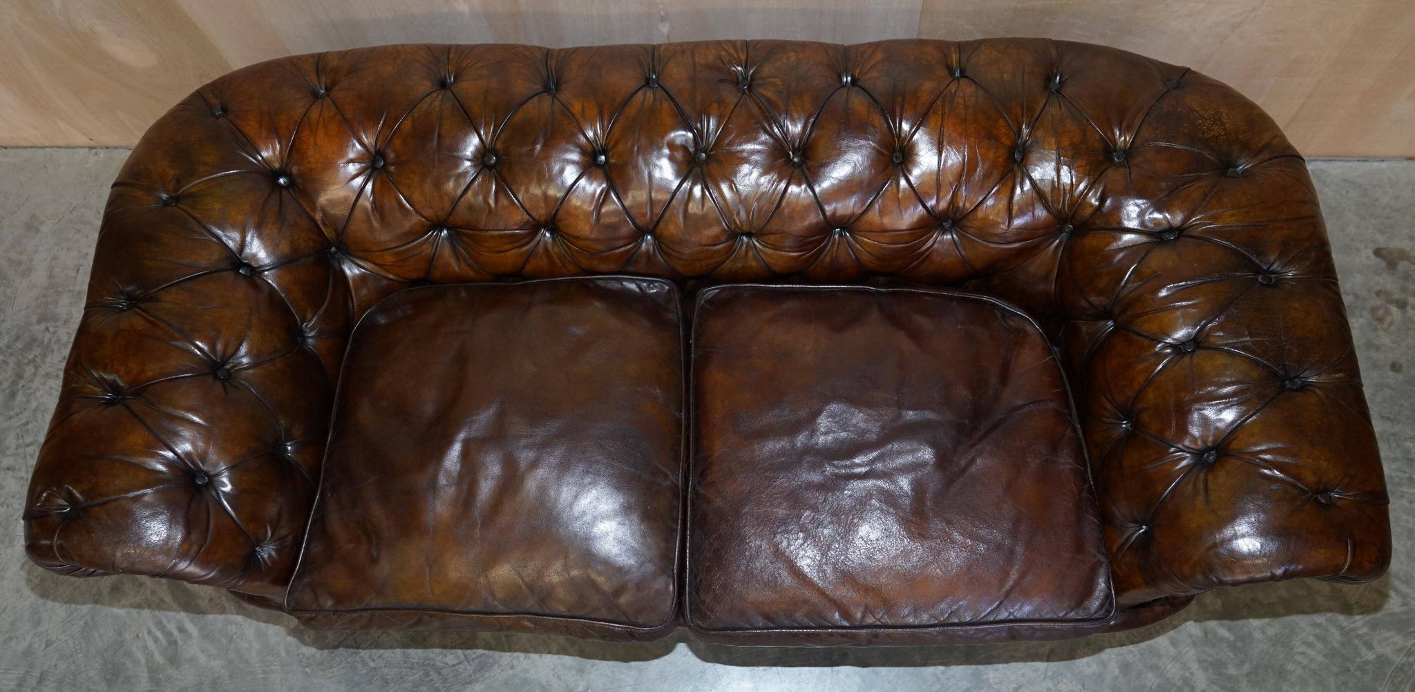 Victorian Chesterfield leather upholstered canapé with feather cushions.