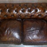 Victorian Chesterfield leather upholstered canapé with feather cushions.