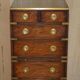 Pair of vintage military campaign high chests of drawers with leather tops.