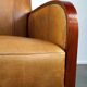 Luxurious cowhide Art Deco design armchair with wooden armrests and cognac-colored leather