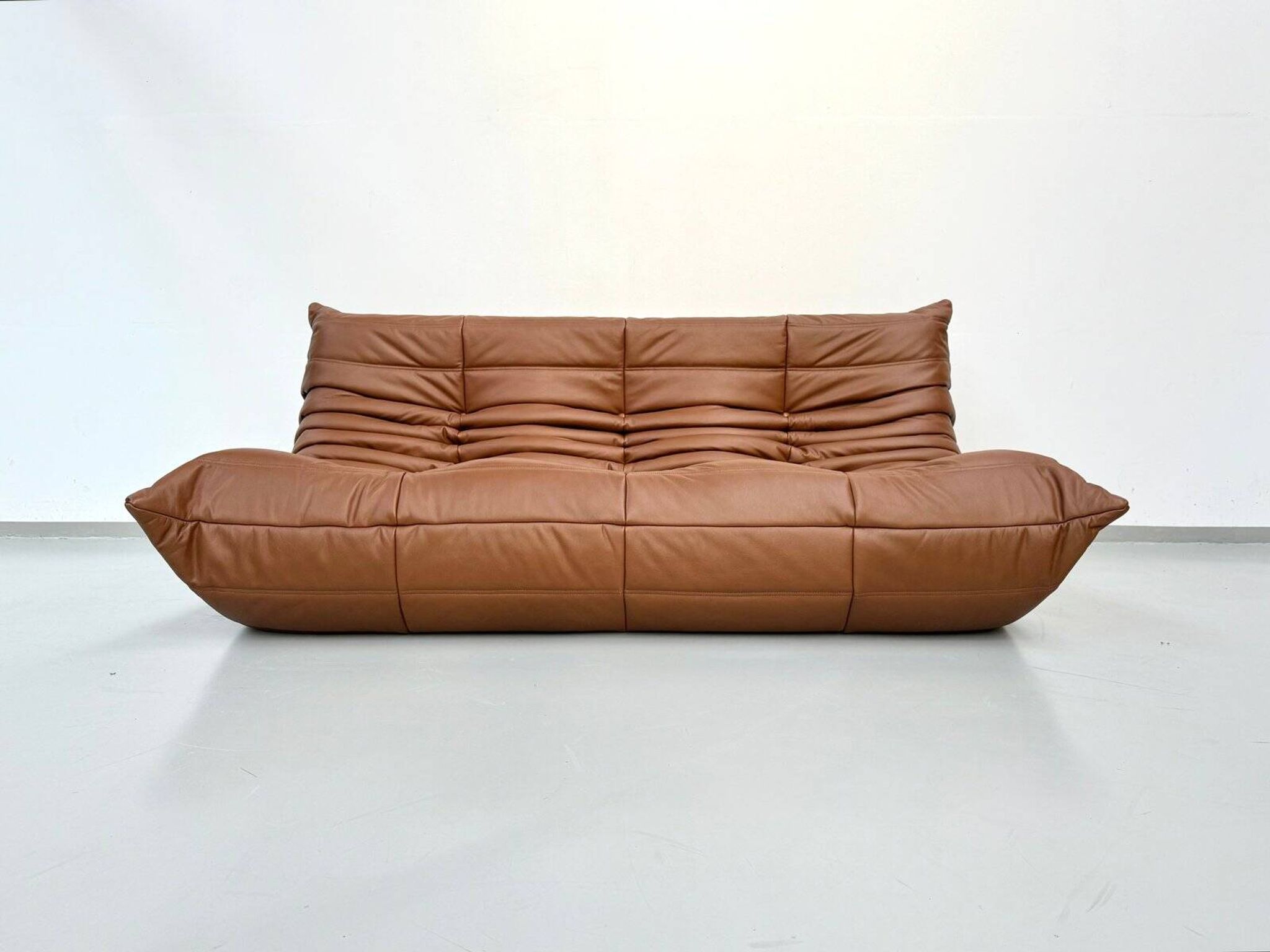 Three-seater Togo sofa in dark cognac leather by Michel Ducaroy for Ligne Roset.