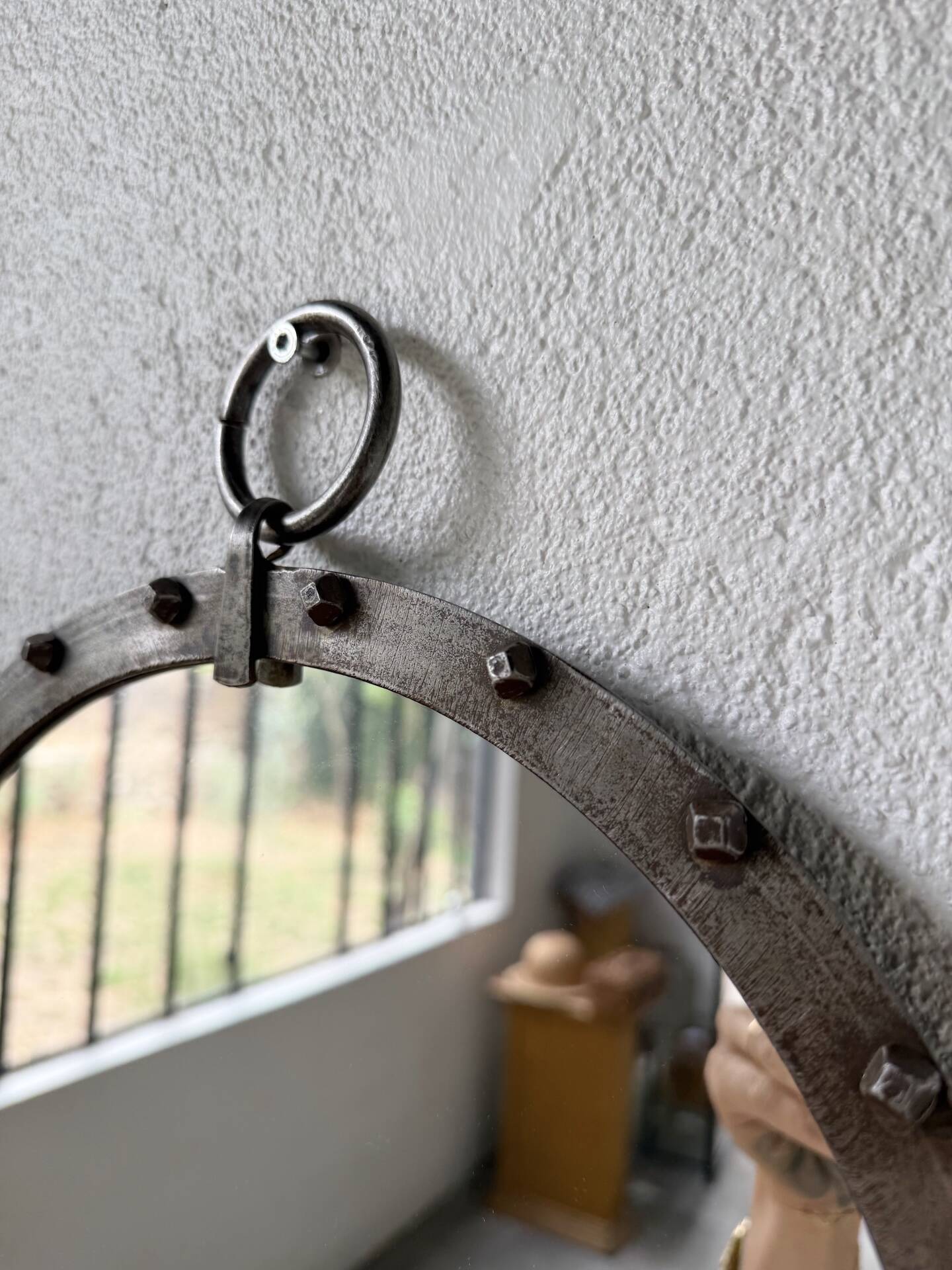Brutalist round mirror with wrought iron and studs.