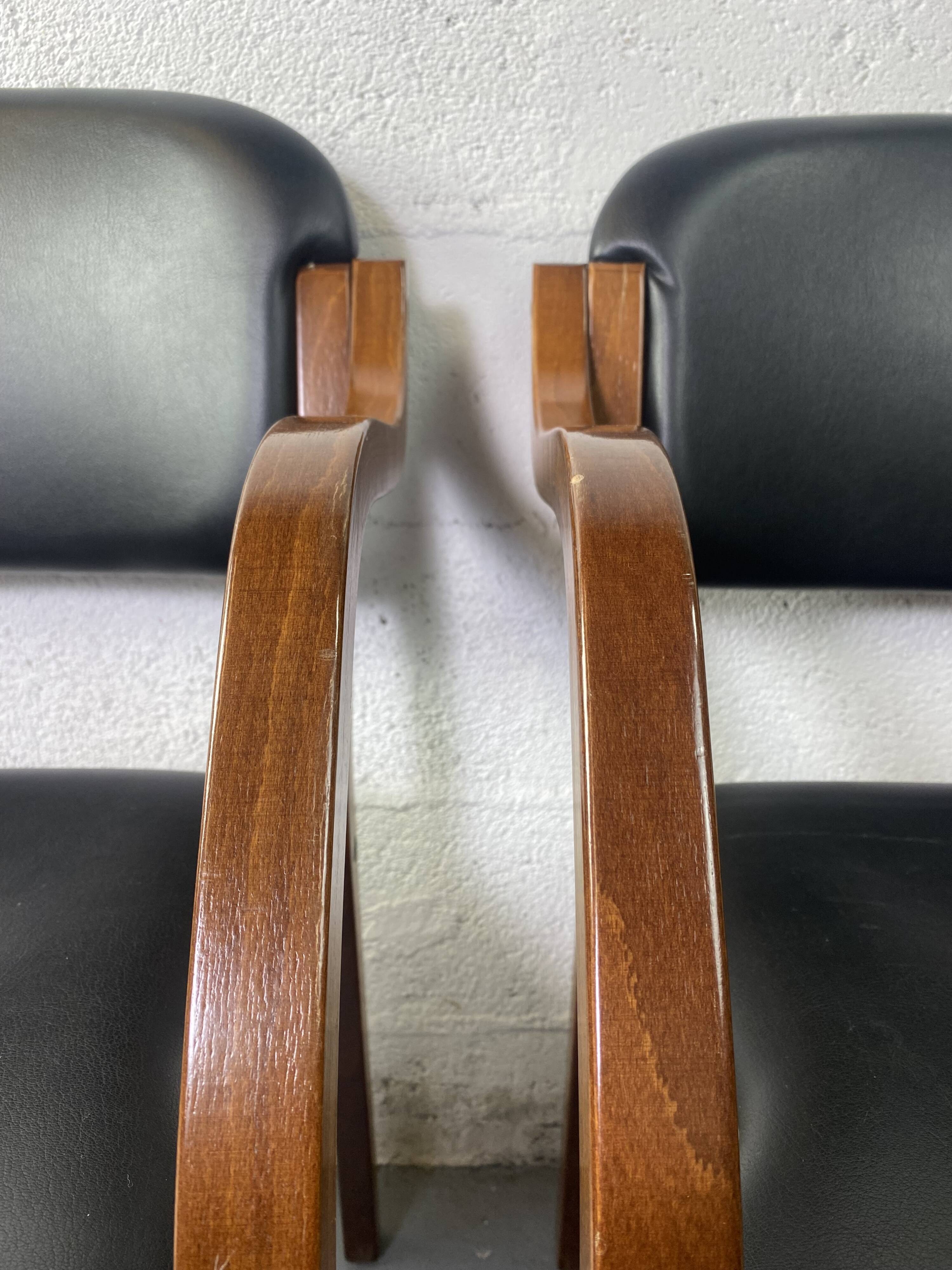 Paire de fauteuils en cuir et bois